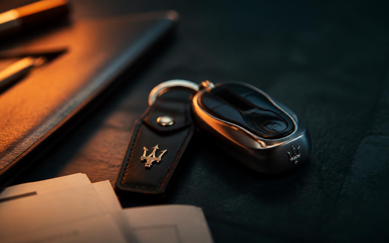 Car key and documents on a dark surface lit by a warm light